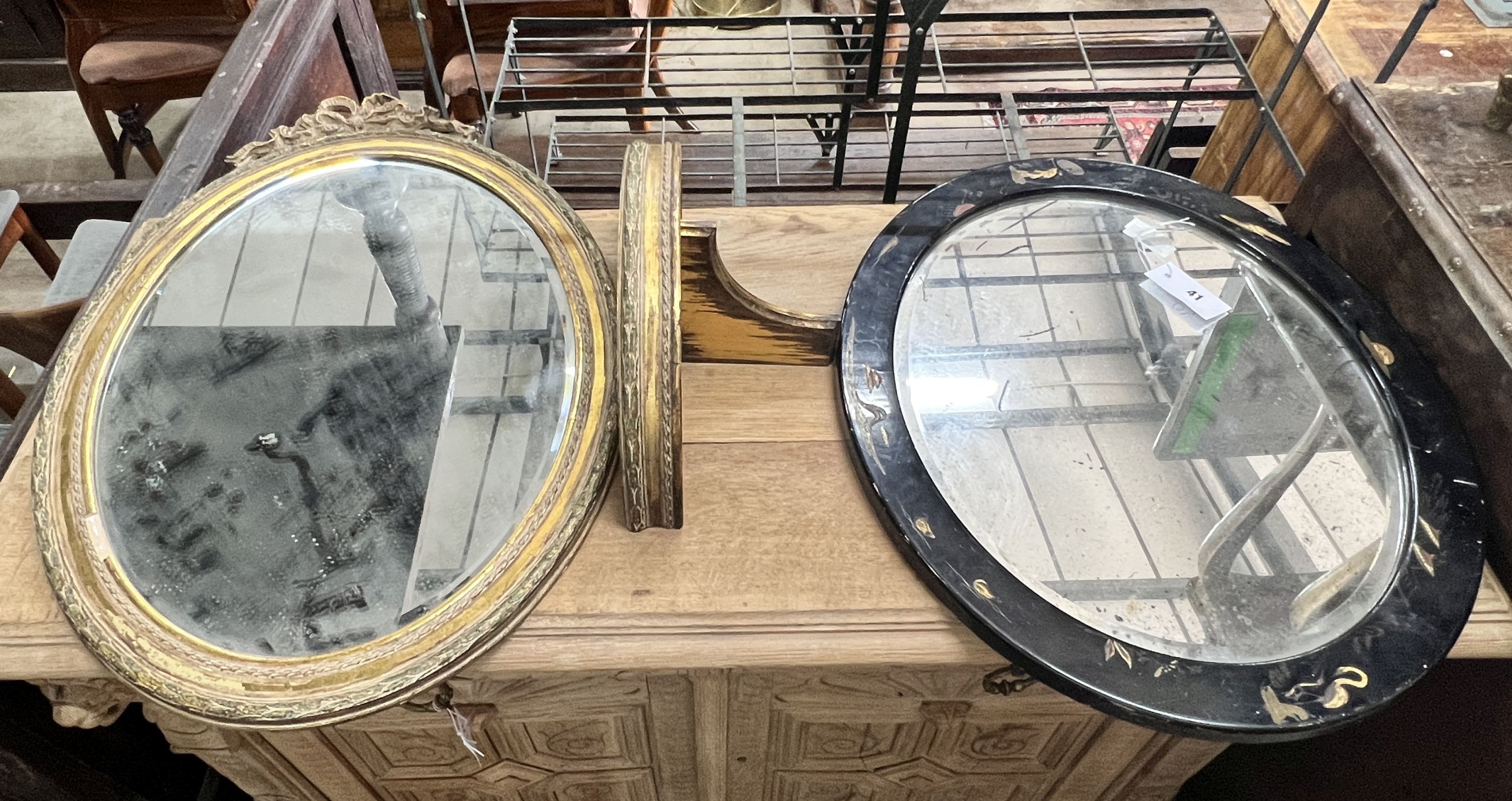An oval gilt framed wall mirror, height 70cm, a matching wall bracket and an oval chinoiserie lacquered wall mirror, height 48cm
